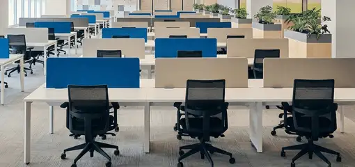 Modern open-plan office space featuring clean workstations, ergonomic chairs, and sanitized carpets provided by professional office cleaning services in Jersey City, NJ.